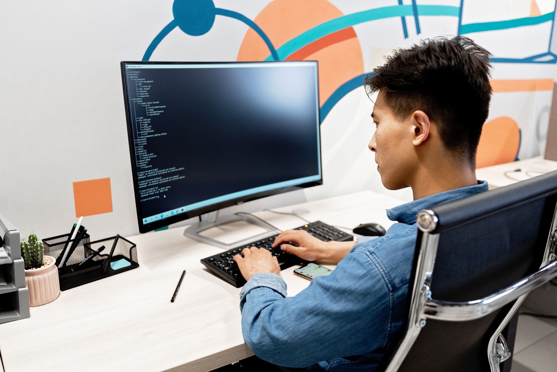 Programista Java pracuje przy dużym monitorze w nowoczesnym biurze