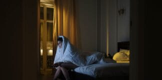 Nocne zmagania z lękiem i bezsennością: psalmy, które mogą ukoić serce i myśli Kobieta owinięta kocem ogląda telewizję podczas bezsennej nocy