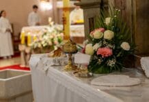Spowiedź z całego życia – jak się przygotować i ile czasu trwa? Ołtarz z kwiatami i naczyniami euchar